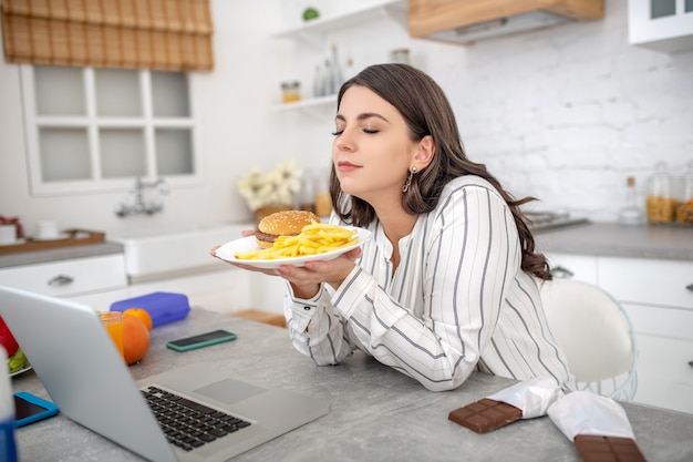 Mujer en una blusa de rayas sosteniendo un plato con comida