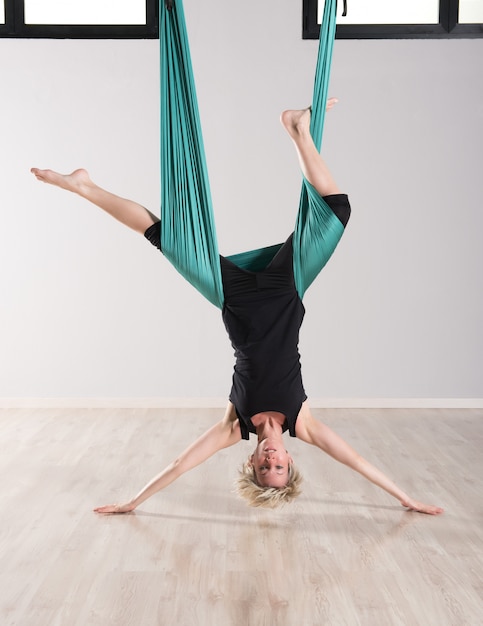 Foto mujer boca abajo sola haciendo yoga aéreo