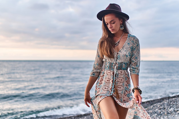 Mujer boho chic con vestido largo y sombrero de fieltro