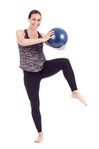 Mujer con bola azul levantando la rodilla