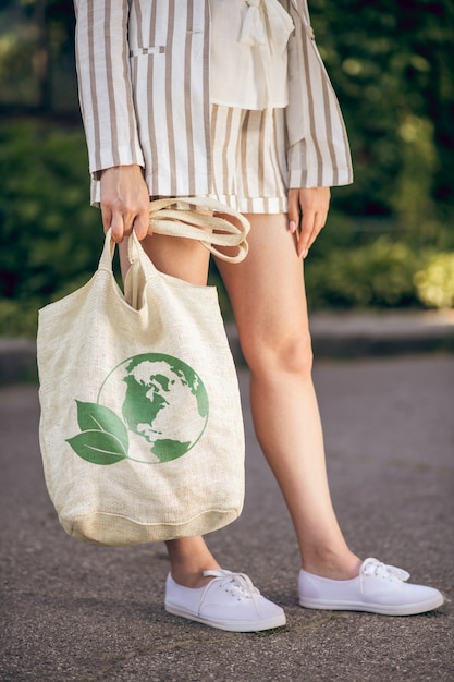Foto mujer con bolsa ecológica. cerrar imagen de una mujer de pie en la calle con bolsa ecológica en las manos