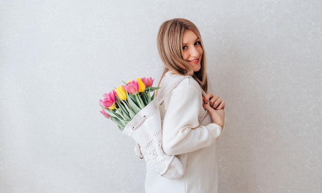 Mujer con bolsa de flores de tulipanes