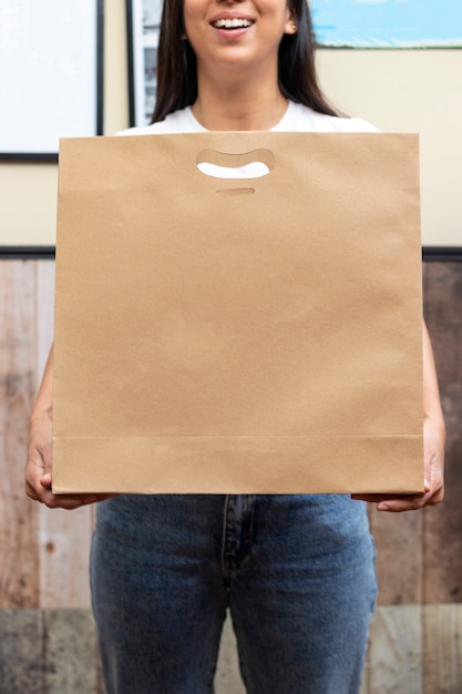 Foto mujer con bolsa de papel, lista para entrega