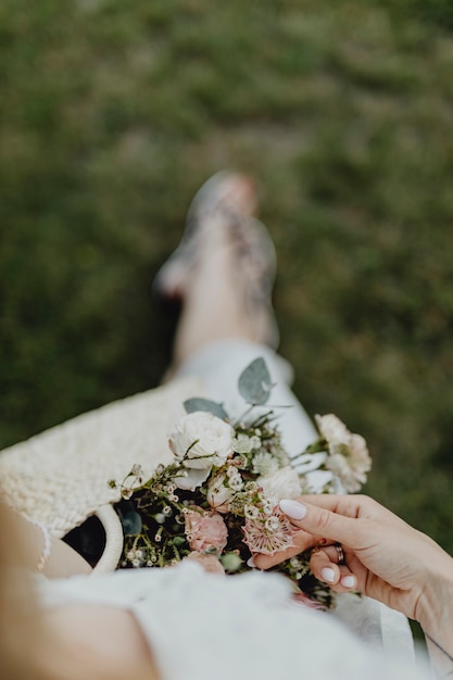 Mujer con una bolsa tejida llena de flores.