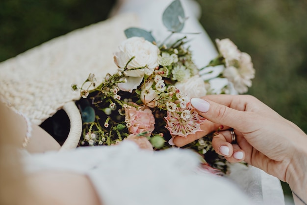 Mujer con una bolsa tejida llena de flores.