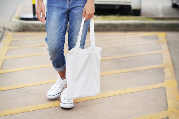 Mujer con bolsa de tela blanca en el parque