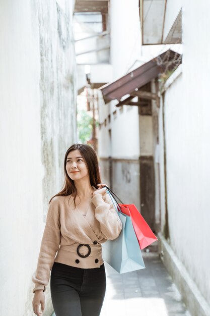 Mujer con bolsas de papel disfrutando de las compras