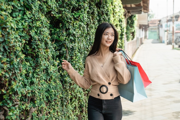 Mujer con bolsas de papel disfrutando de las compras