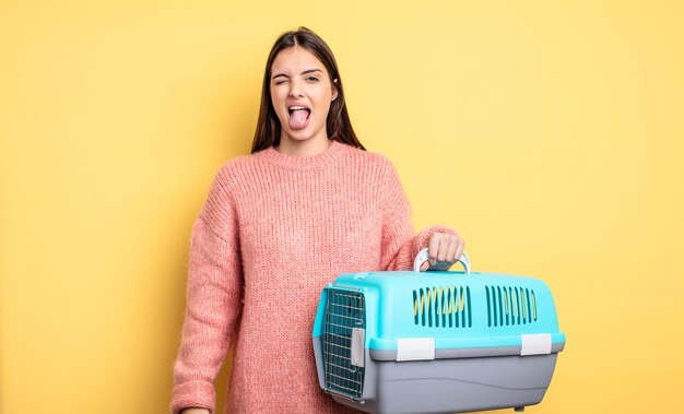 Mujer bonita con actitud alegre y rebelde bromeando y sacando la lengua concepto de portador de mascotas