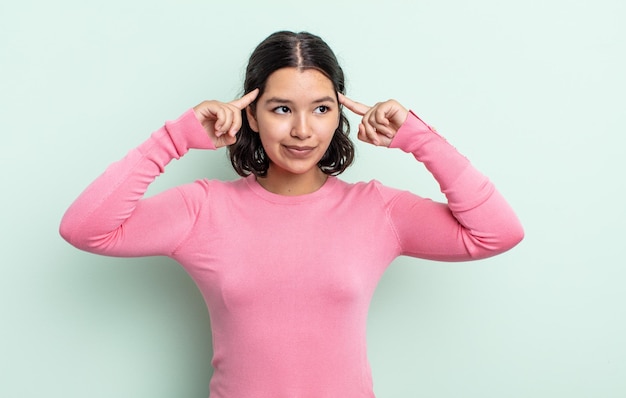 Mujer bonita adolescente que se siente confundida o que duda de concentrarse en una idea pensando mucho buscando copiar el espacio al costado