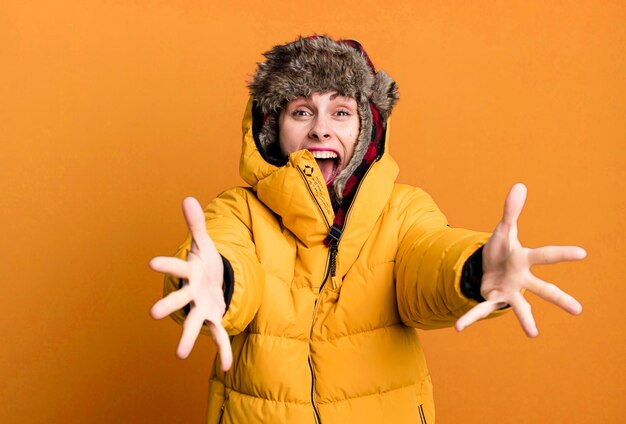 Mujer bonita adulta joven con anorak y sombrero de invierno