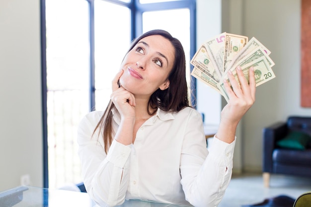Foto mujer bonita adulta joven con billetes de dólar en casa