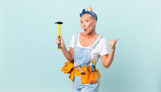 Mujer bonita adulta con un martillo. concepto de reparación