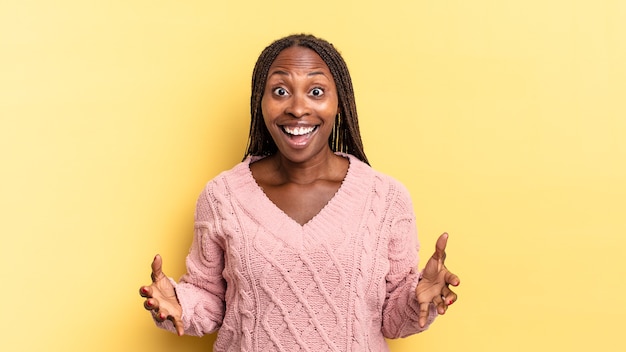 Mujer bonita afro negra que se siente feliz, asombrada, afortunada y sorprendida, como decir omg en serio? Increíble