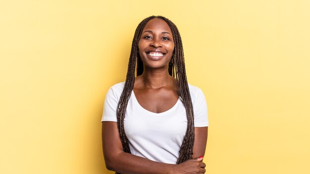 Mujer bonita afro negra riendo tímidamente y alegremente, con una actitud amistosa y positiva pero insegura