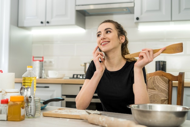 Mujer bonita amasando masa en casa, cocinando alimentos para un estilo de vida saludable. Crudo