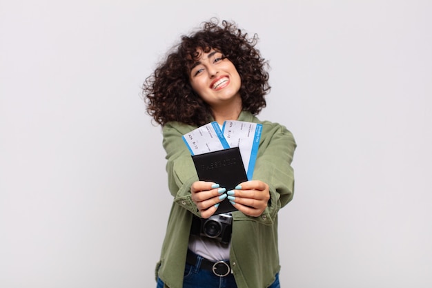 Mujer bonita árabe con un avión y billetes de embarque. concepto de viaje