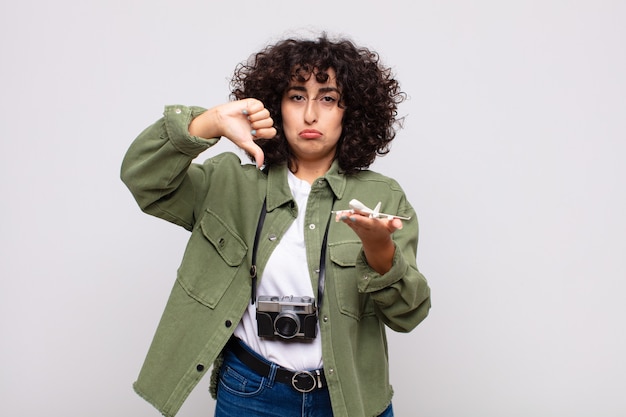 Mujer bonita árabe con un modelo de avión