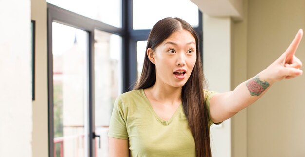 Mujer bonita asiática en casa con fondo de ventanas grandes