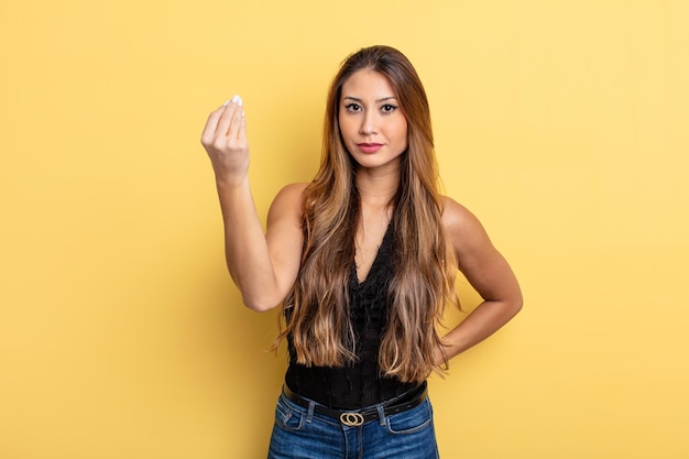 Mujer bonita asiática haciendo capice o gesto de dinero, diciéndole que pague