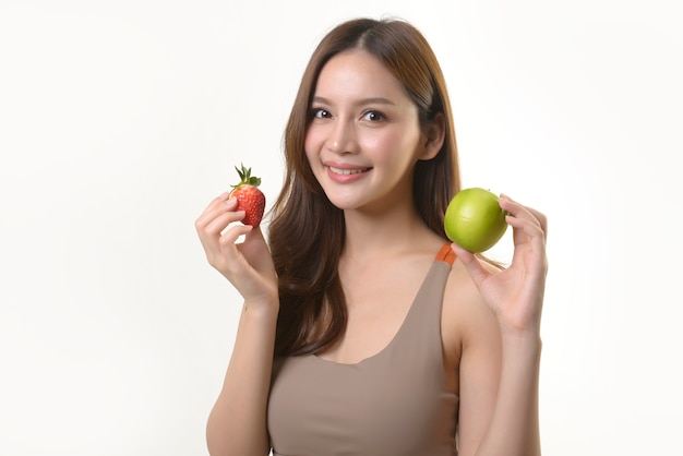 Mujer bonita asiática con manzana y fresa