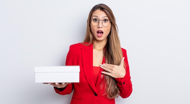 Mujer bonita asiática mirando consternado y sorprendido con la boca abierta, apuntando a sí mismo. concepto de caja en blanco