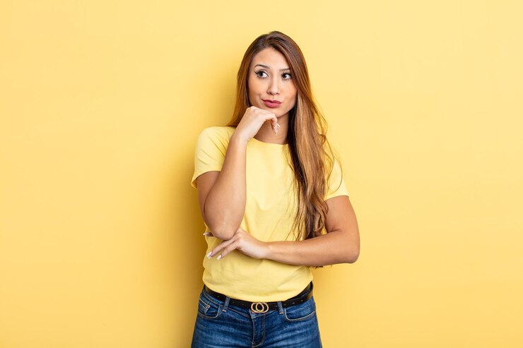 Foto mujer bonita asiática pensando, sintiéndose dudosa y confundida, con diferentes opciones, preguntándose qué decisión tomar