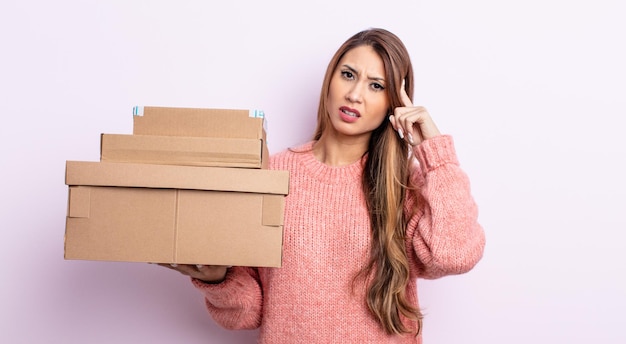 Mujer bonita asiática que se siente confundida y perpleja, mostrando que estás loca. concepto de cajas de almacenamiento