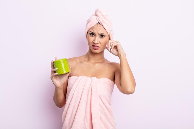 Mujer bonita asiática que se siente confundida y perpleja, mostrando que estás loca. concepto de cuidado y mascarilla para el cabello