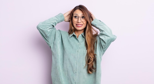 Mujer bonita asiática que se siente estresada, preocupada, ansiosa o asustada, con las manos en la cabeza, aterrorizada por el error