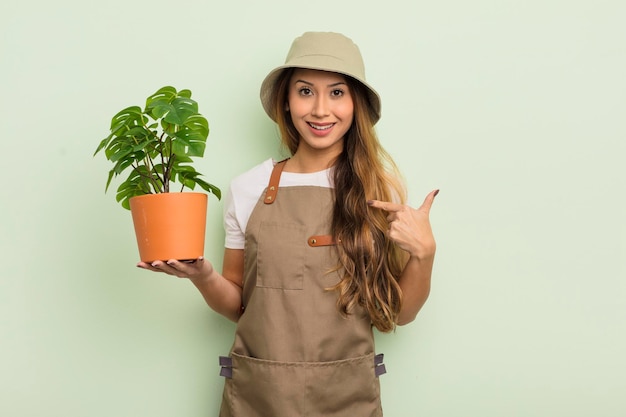 Mujer bonita asiática que se siente feliz y se señala a sí misma con un concepto de jardinero emocionado