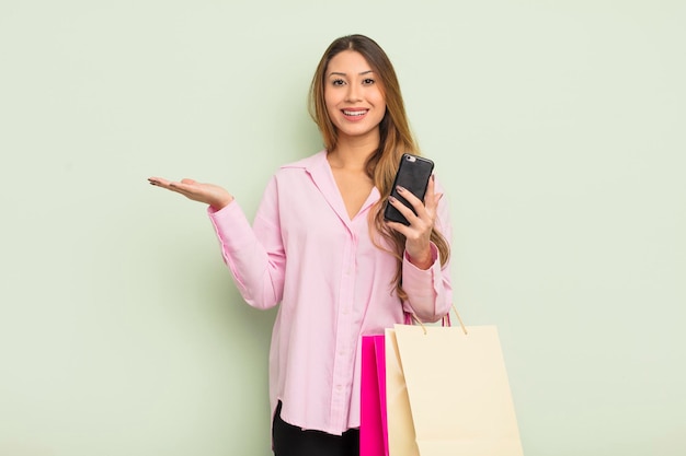 Mujer bonita asiática que se siente feliz, sorprendida al darse cuenta de una solución o idea. concepto de bolsas de compras