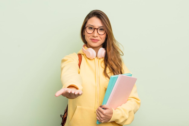 Mujer bonita asiática sonriendo alegremente con amabilidad y ofreciendo y mostrando un concepto. concepto de estudiante universitario