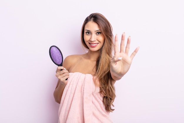 Mujer bonita asiática sonriendo y mirando amigable, mostrando el número cuatro. concepto de cuidado del cabello