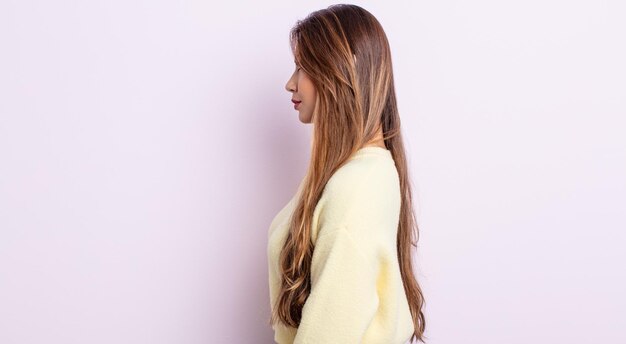 Mujer bonita asiática en vista de perfil mirando para copiar el espacio por delante, pensando, imaginando o soñando despierto