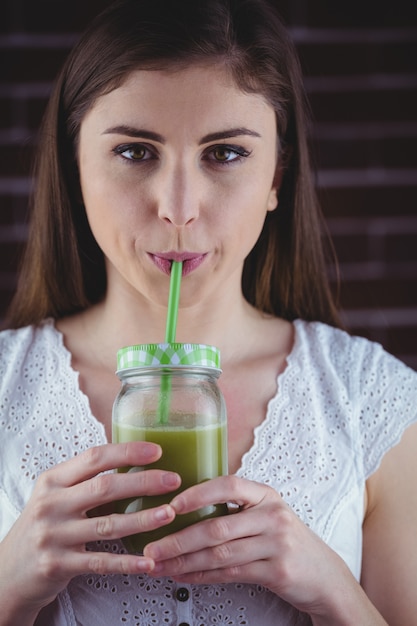 Foto mujer bonita bebiendo jugo verde