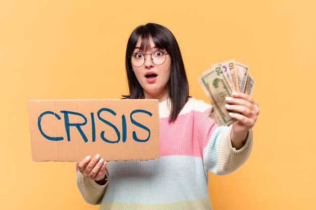 Mujer bonita con billetes de dólar y tablero de crisis