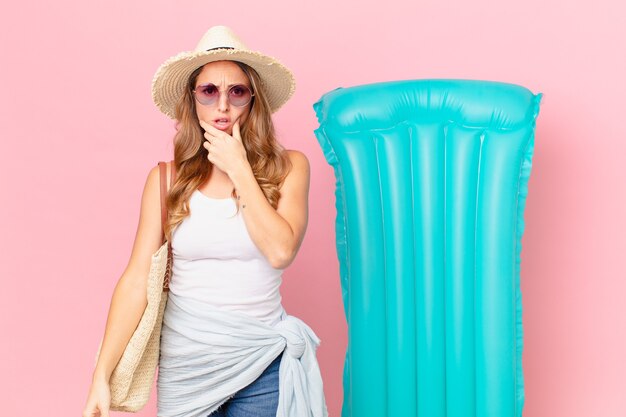 Foto mujer bonita con la boca y los ojos bien abiertos y la mano en la barbilla. concepto de verano