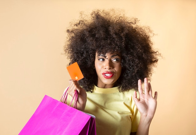 Mujer bonita con bolsas de compras sobre fondo beige de tarjeta de crédito de viernes negro