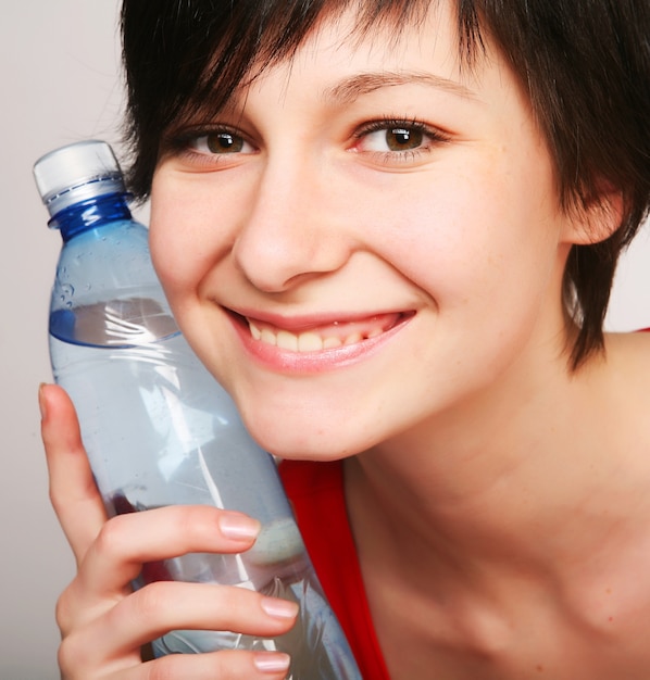 Mujer bonita con botella de agua limpia