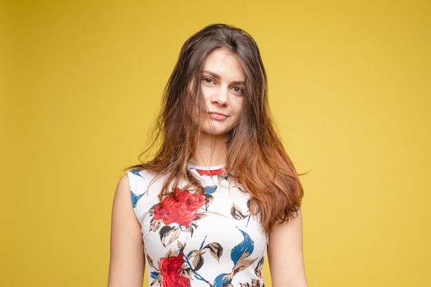 Mujer bonita con cabello desordenado en una mano y cepillo para el pelo en otra