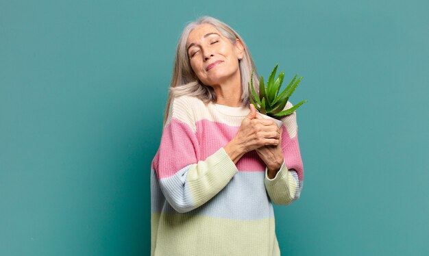 Mujer bonita de cabello gris con un cactus