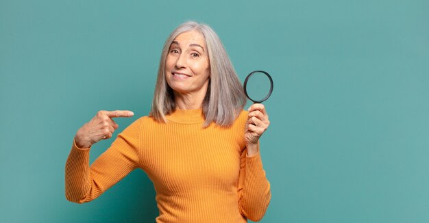 Mujer bonita de cabello gris con una lupa