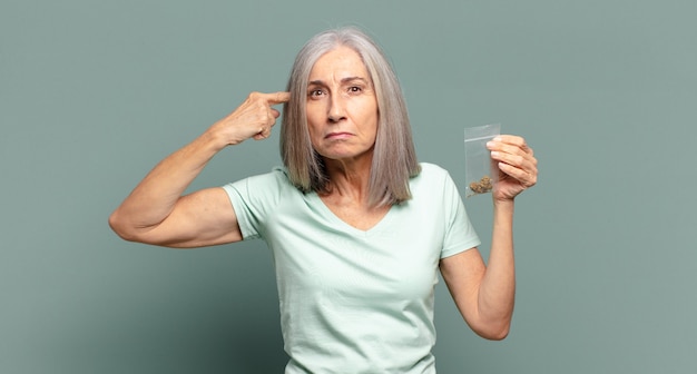 Mujer bonita de cabello gris con marihuana