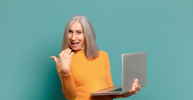 Mujer bonita de cabello gris con un portátil