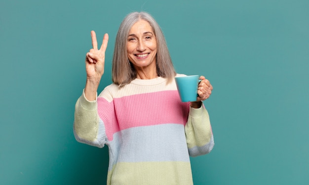 Mujer bonita de cabello gris con una taza de café