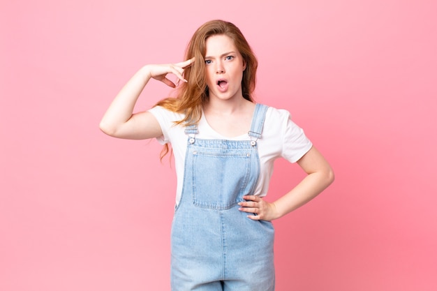 Mujer bonita cabeza roja que parece sorprendida, dándose cuenta de un nuevo pensamiento, idea o concepto