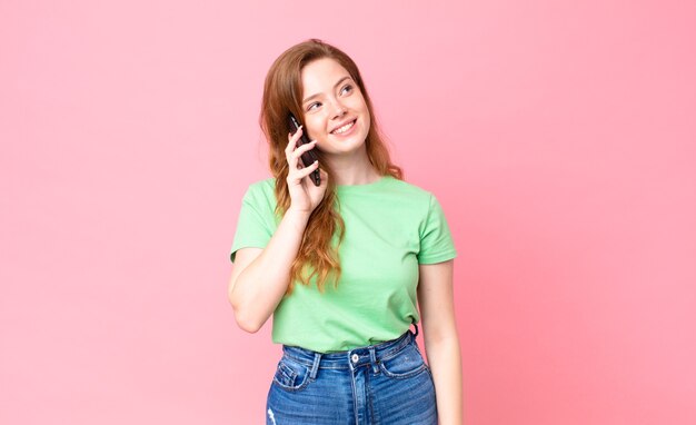 Mujer bonita cabeza roja con su teléfono inteligente