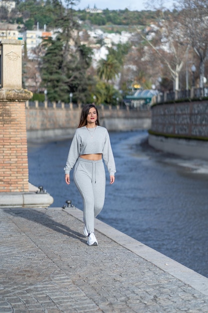 Mujer bonita caminando por la orilla del río en la puesta de sol