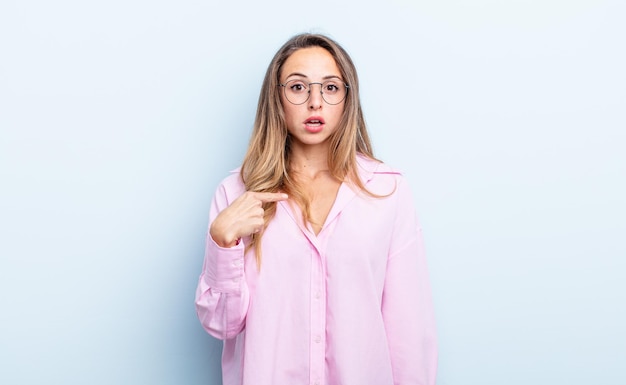 Mujer bonita caucásica mirando consternado y sorprendido con la boca abierta, apuntando a sí mismo